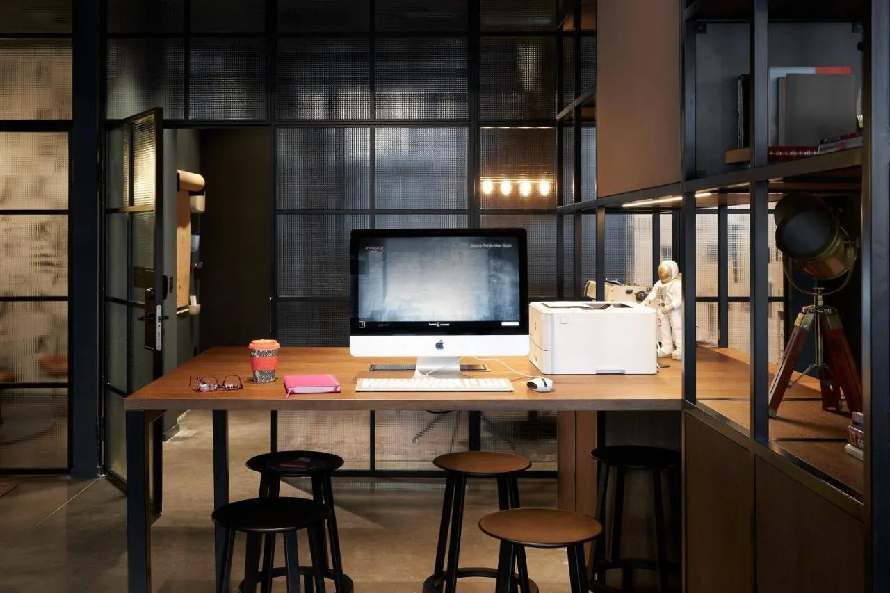 an office with a desk with a computer and stools at Moxy Edinburgh in Edinburgh